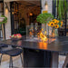 Black Elementi Plus Koln Marble Porcelain Bar Table showcasing its flames and the optional windscreen