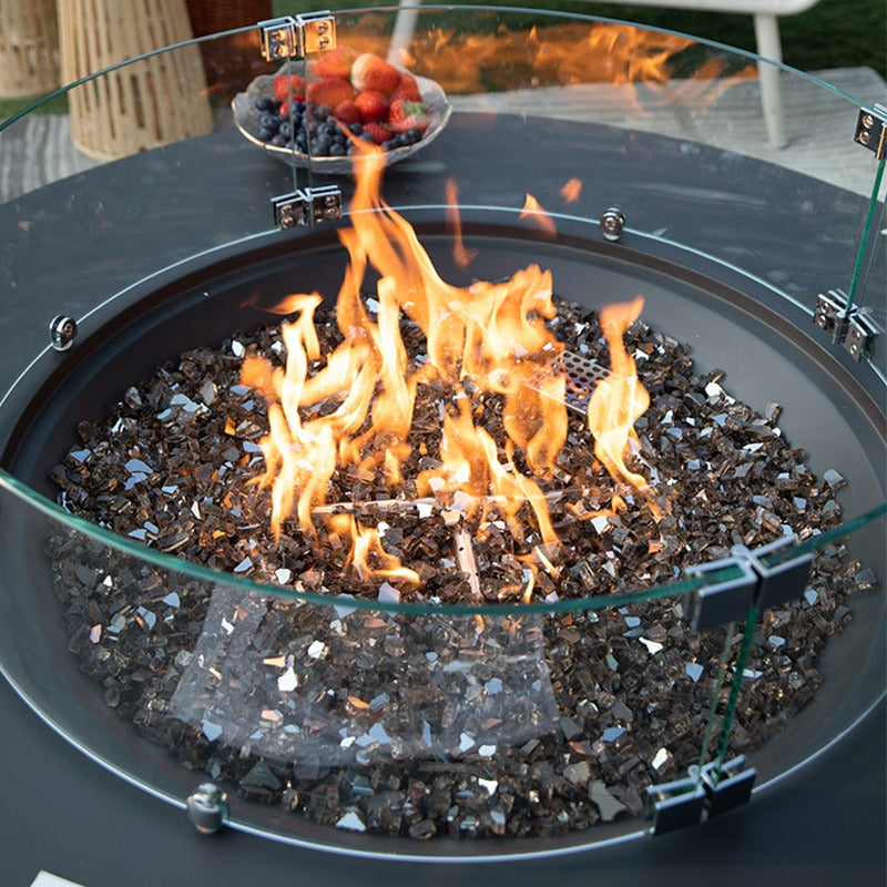 Colosseo Round Fire Table in Dark grey showcasing its flames with windscreen