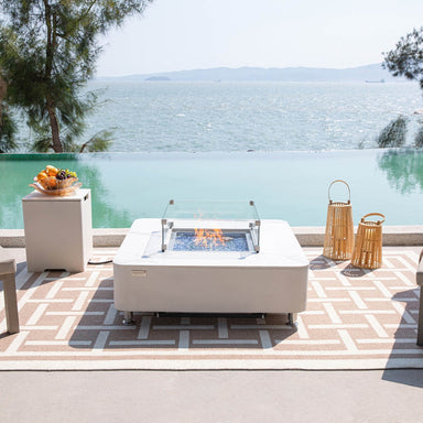Elementi Plus Annecy Porcelain Fire Table in White placed at the outdoor terrace near the sea
