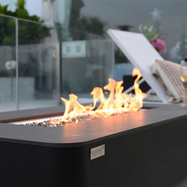 Elementi Plus Valencia Fire Table with its glowing flames placed on the outdoor terrace