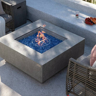 Light Grey Victoria & Bergen Square Concrete Fire Table by Elementi Plus is placed outdoors to provide heat