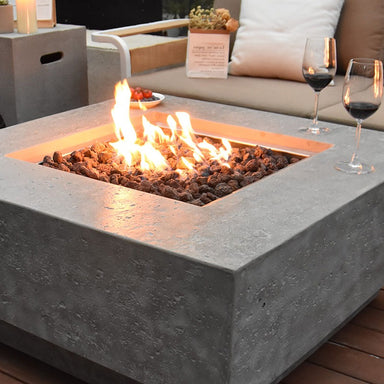Manhattan Fire Table by Elementi showcasing its flames and lava rocks placed outdoors
