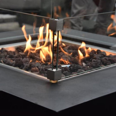 Modeno Aurora Square Concrete Fire Pit showcasing its flames with the optional windscreen to provide heat outdoors