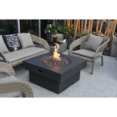 Modeno Branford Fire Pit in Slate Black placed at the patio to provide heat with chairs and couches around