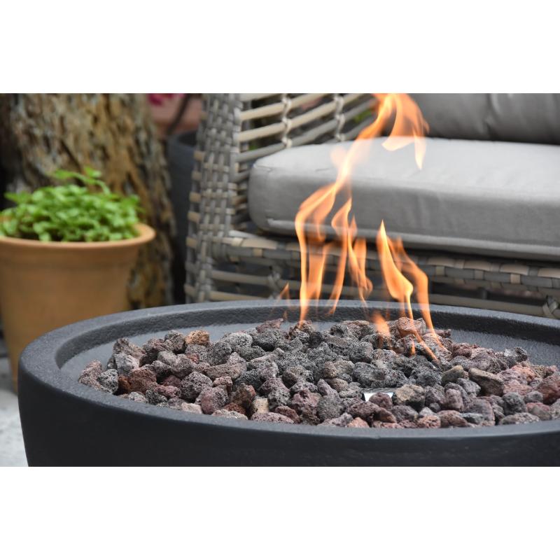 Modeno Jefferson Round Concrete Fire Bowl showcasing its flames with the Lava Rocks