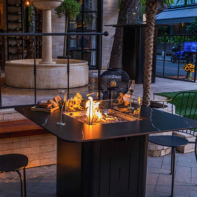 Showcasing the flames and the design of the Brugge Marble Porcelain Dining Table placed outdoors