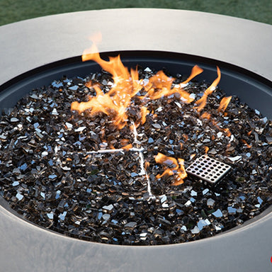 The Colosseo Round Fire Table by Elementi Plus showcasing its flames and its fireglass