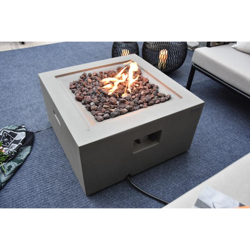 The Modeno Ridgefield Square Concrete Fire Pit in Light Gray showcasing its flames and lava rocks to provide heat