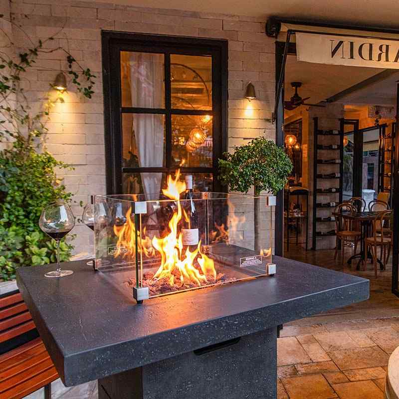 The Montreal Bar Table in Dark Grey with its full flames windscreen providing protection