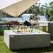 showcasing the flames of the Grey Capertee Square Concrete Fire Table on the lawn area